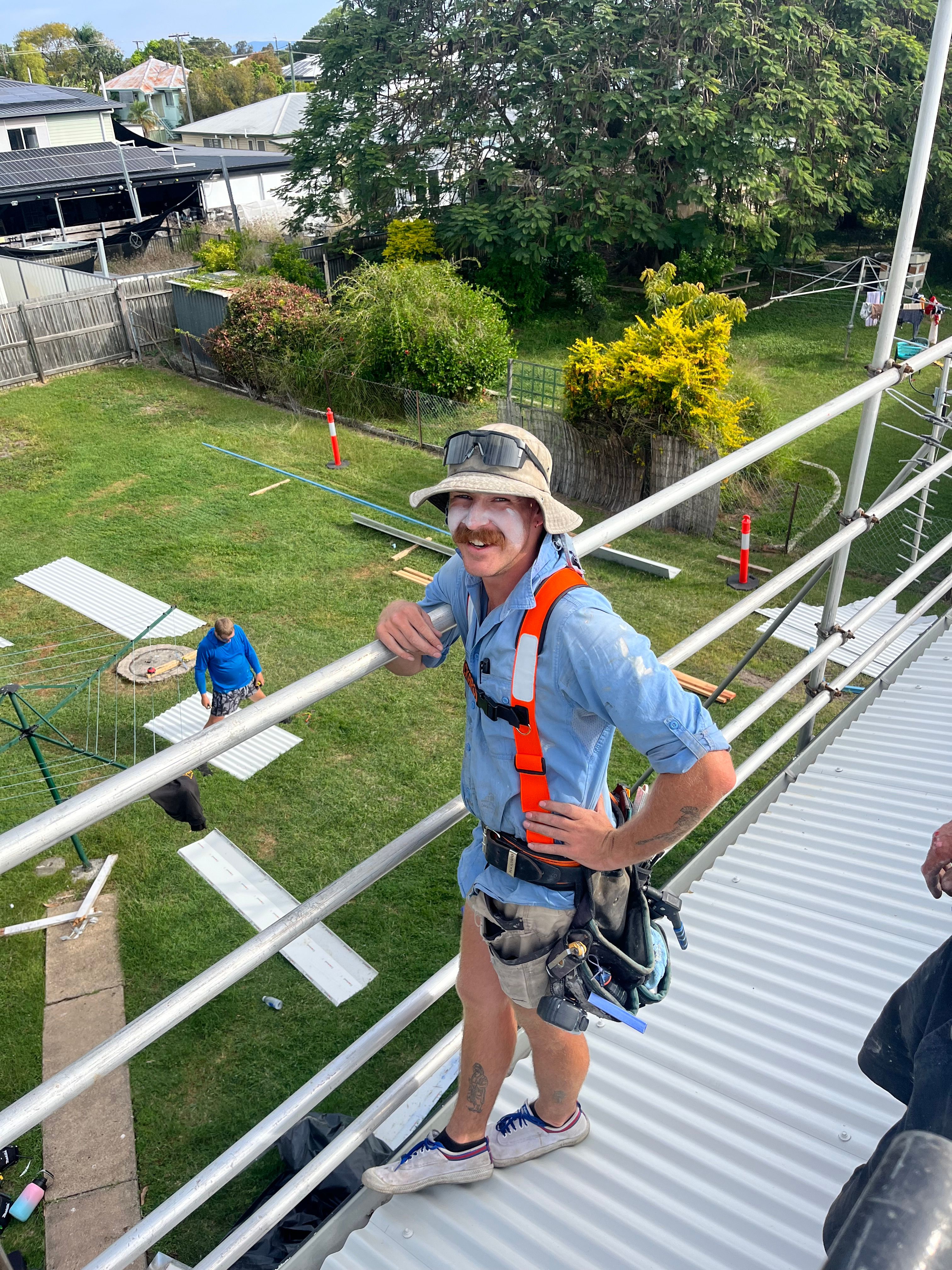 Roofer in safety harness on roof