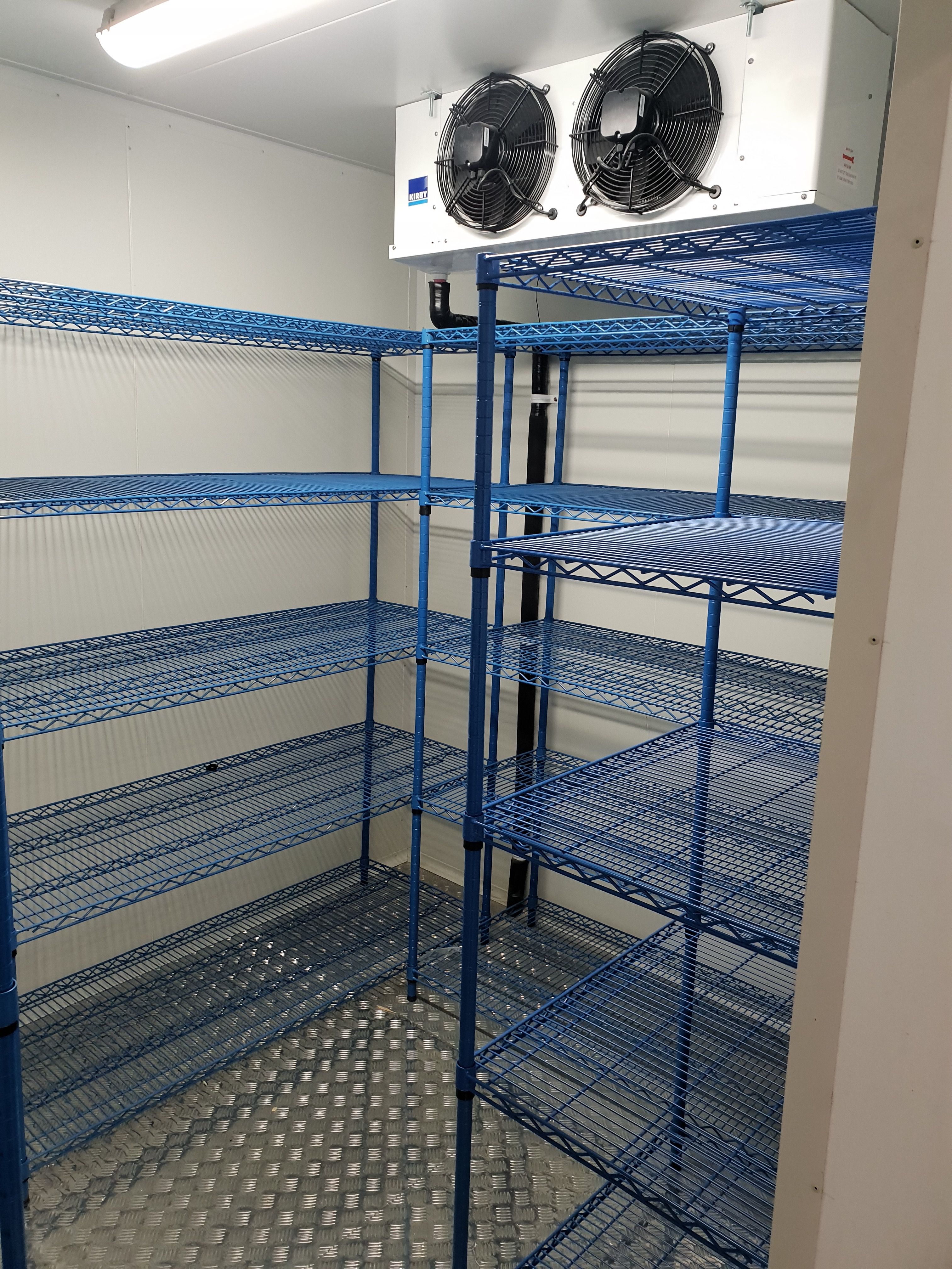 Completed coolroom interior with blue wire shelving and evaporator