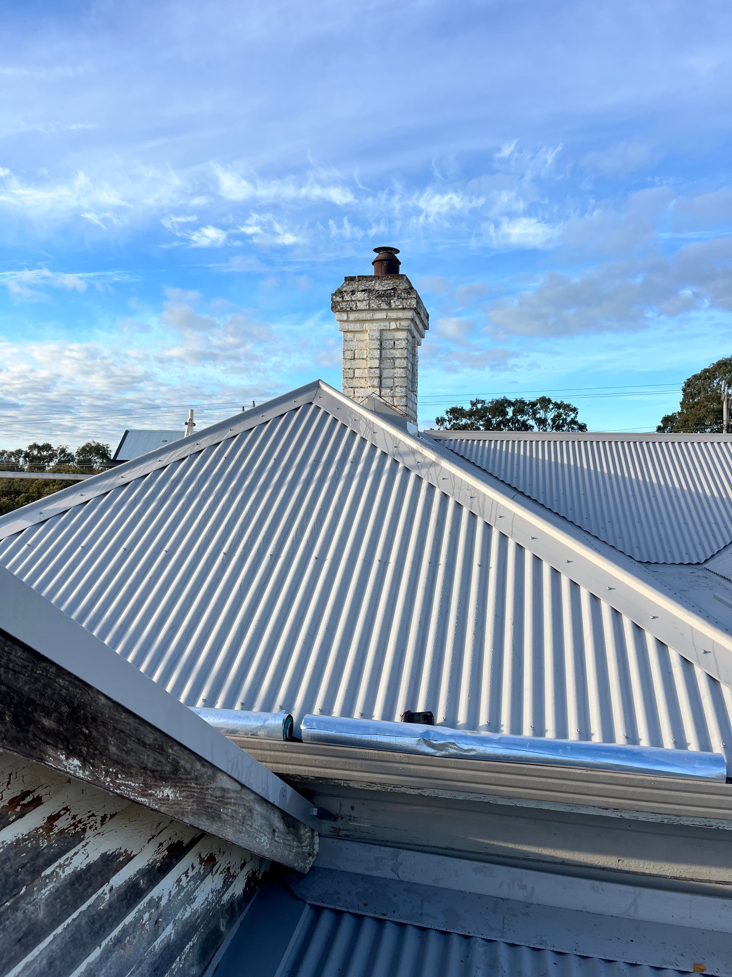 Metal re-roof with stone chimney